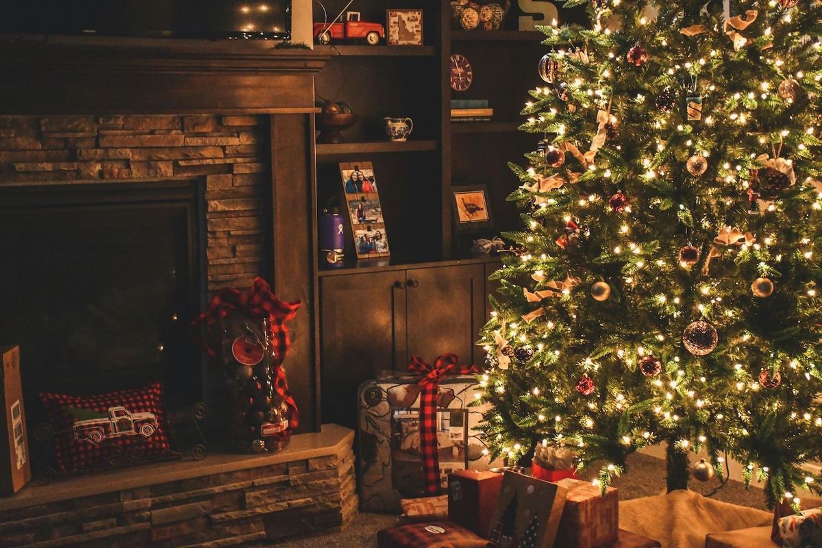 christmas tree next to the fireplace and gifts