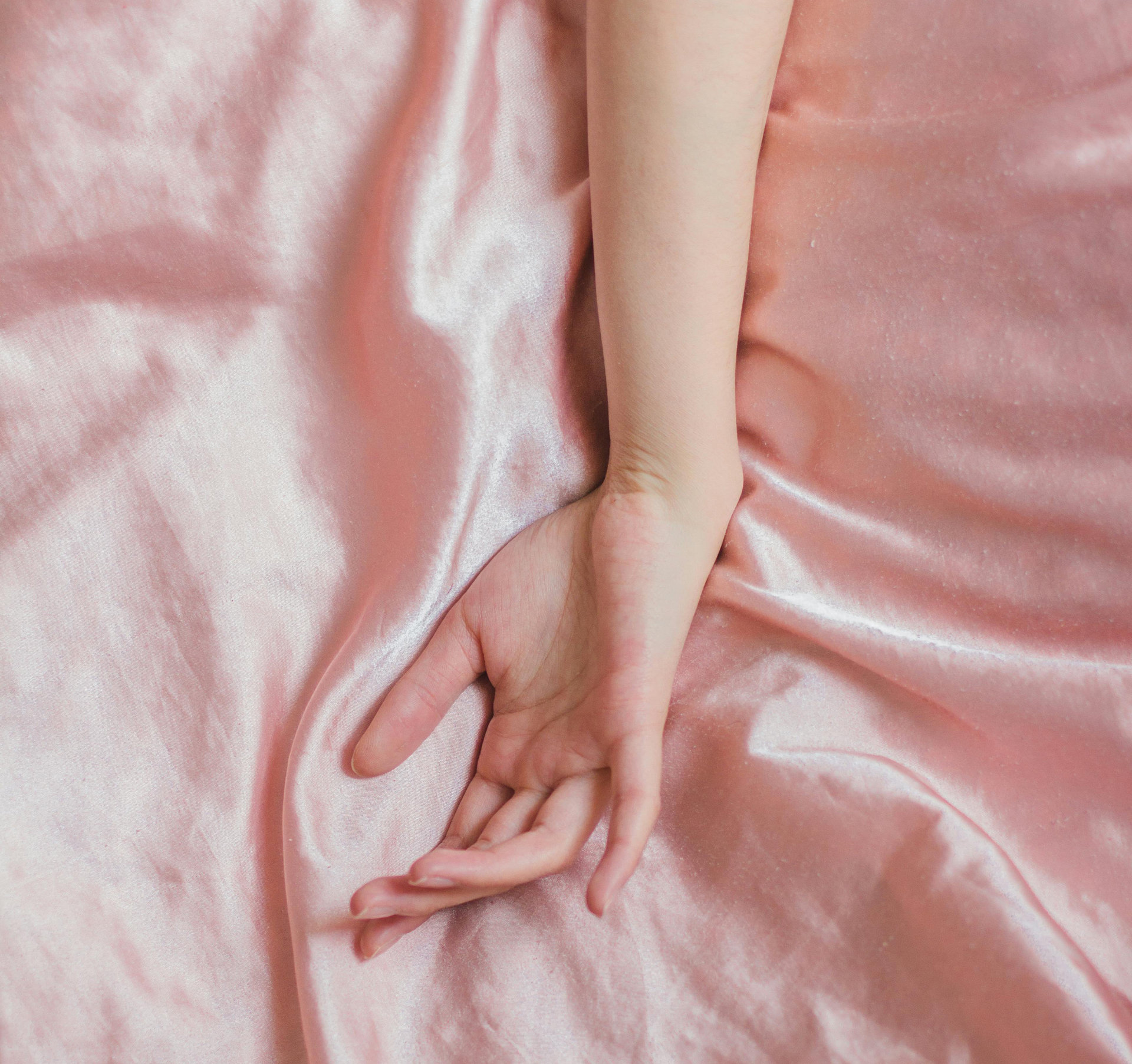hand-on-pink-satin-sheets)
